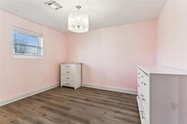 unfurnished dining area featuring dark hardwood / wood-style flooring and an inviting chandelier