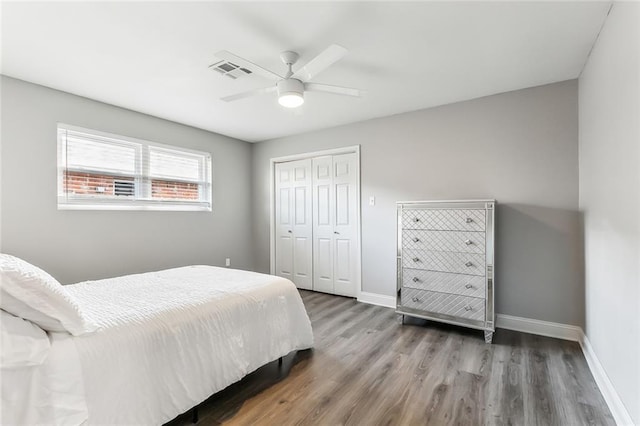 bedroom featuring ceiling fan, dark hardwood / wood-style flooring, and a closet