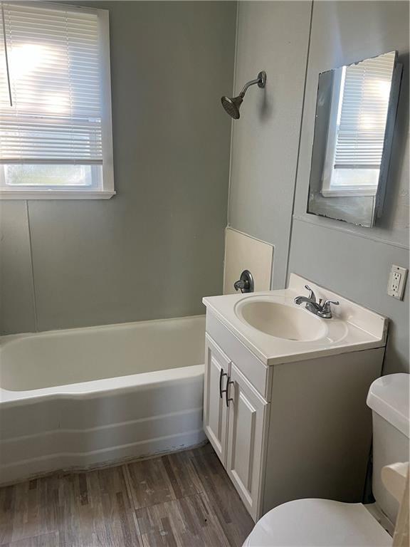 bathroom with hardwood / wood-style floors, vanity, and toilet