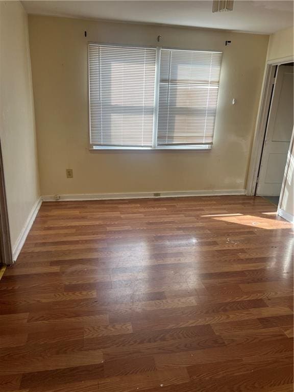 unfurnished room with plenty of natural light and dark wood-type flooring