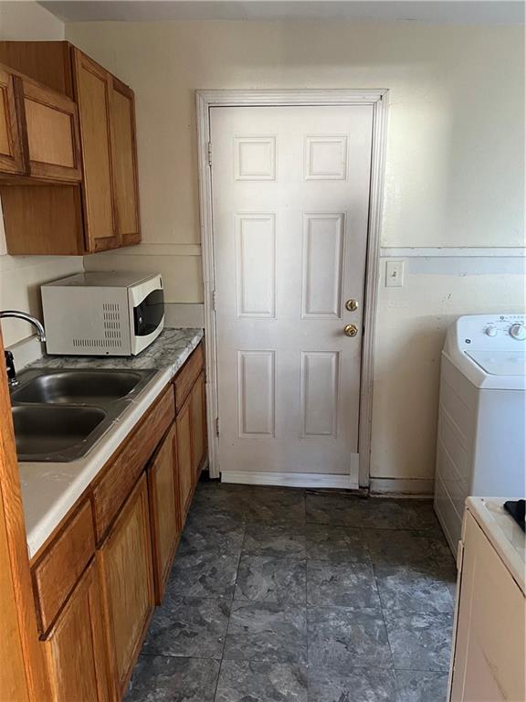 laundry area with cabinets, washer / dryer, and sink