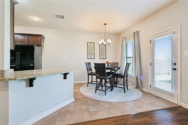 dining room with light hardwood / wood-style floors and a chandelier