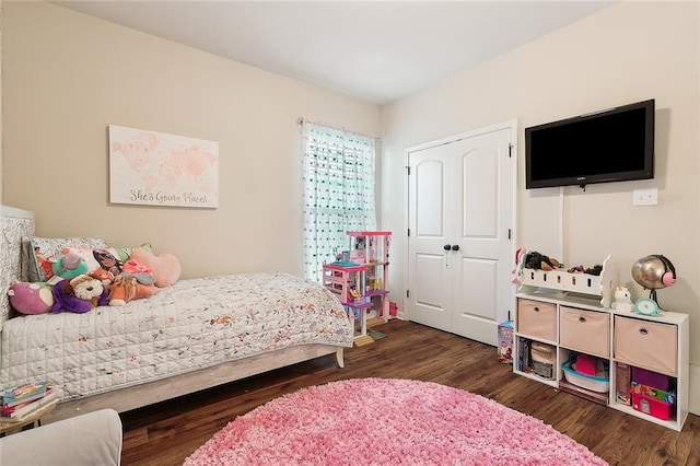 bedroom with dark hardwood / wood-style floors and a closet