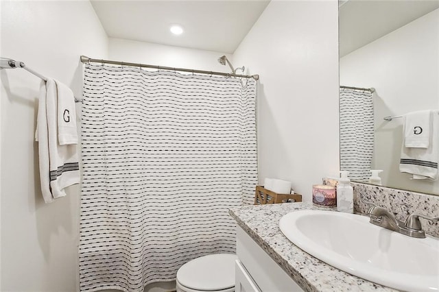 bathroom featuring toilet, curtained shower, and vanity