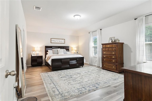 bedroom with multiple windows and light hardwood / wood-style flooring