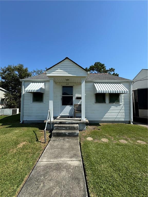 bungalow-style house featuring covered porch and a front lawn