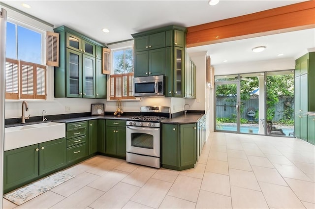 kitchen with green cabinetry, sink, and appliances with stainless steel finishes