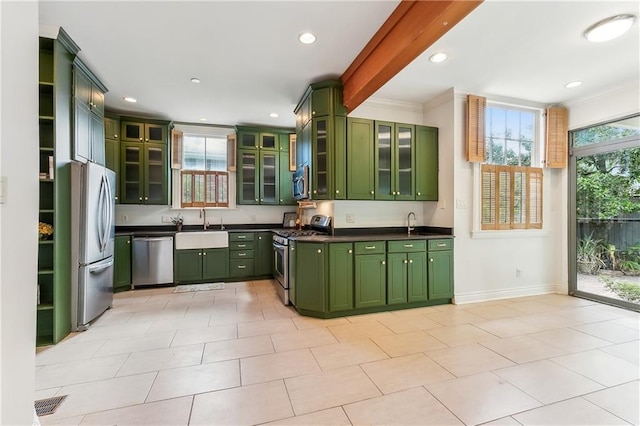 kitchen with sink, green cabinets, appliances with stainless steel finishes, and crown molding