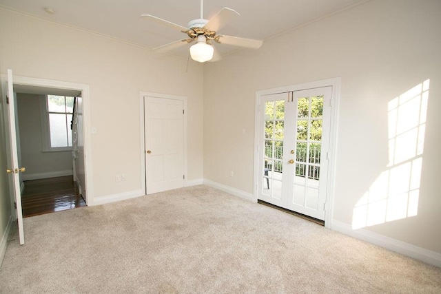 carpeted spare room featuring ceiling fan and french doors