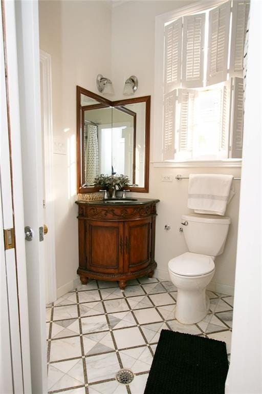 bathroom with toilet, vanity, and tile patterned flooring