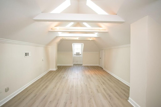 additional living space featuring vaulted ceiling with beams and light hardwood / wood-style floors