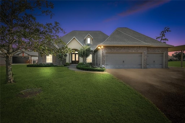 view of front of property with a yard and a garage