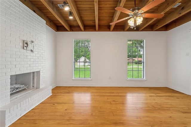 unfurnished living room featuring beam ceiling, a ceiling fan, a wealth of natural light, and light wood-style floors