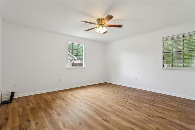 unfurnished room featuring baseboards, ceiling fan, and wood finished floors