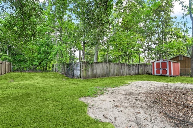 view of yard with an outbuilding, a fenced backyard, and a shed