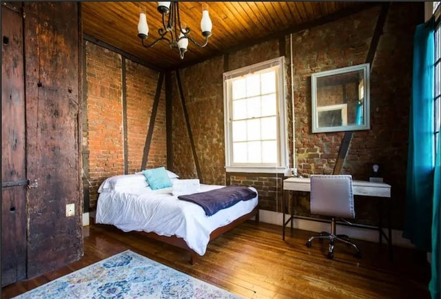 bedroom with hardwood / wood-style floors, wood ceiling, brick wall, and a chandelier