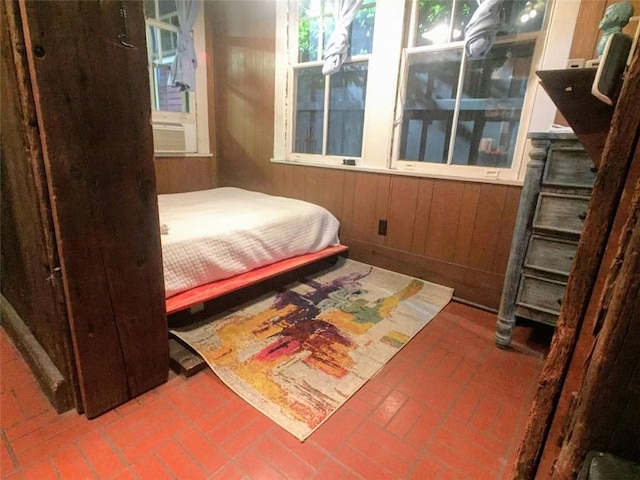 bedroom featuring wooden walls and cooling unit