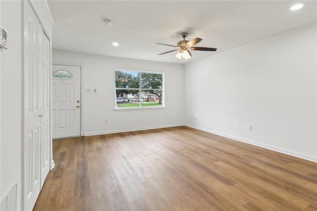 entryway with ceiling fan, crown molding, and light hardwood / wood-style floors