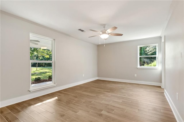 unfurnished room featuring a wealth of natural light, ceiling fan, and light hardwood / wood-style flooring