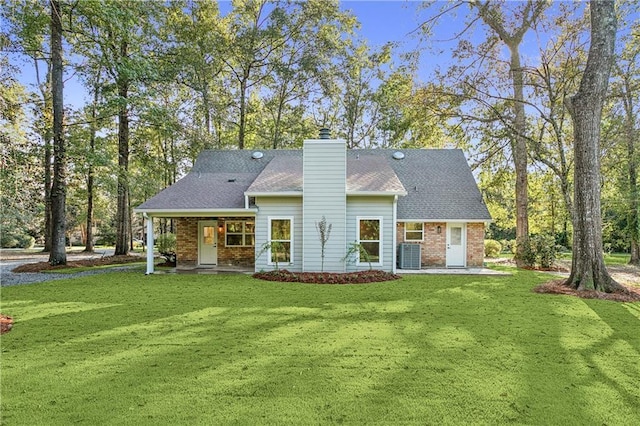 back of property featuring a yard and central AC