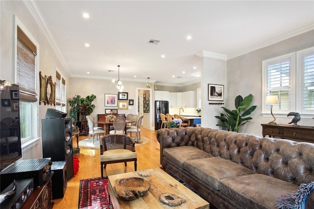 living area with light wood finished floors, visible vents, crown molding, and recessed lighting