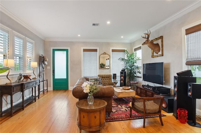 living room featuring visible vents, crown molding, baseboards, and wood finished floors