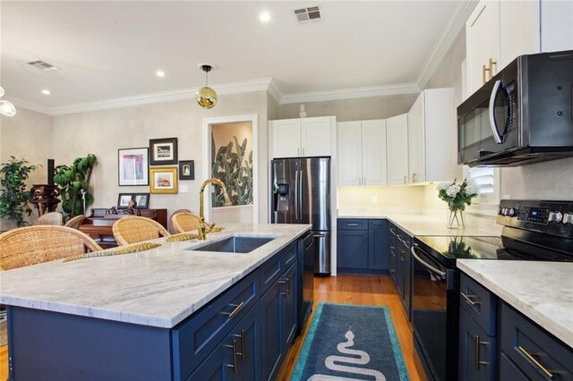 kitchen featuring visible vents, a sink, blue cabinetry, and black appliances