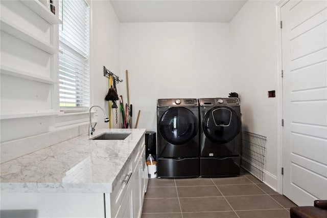 clothes washing area featuring cabinet space, dark tile patterned floors, separate washer and dryer, and a sink