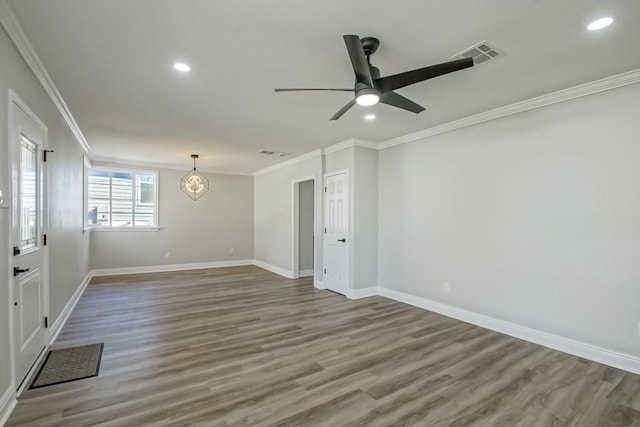 unfurnished room featuring hardwood / wood-style flooring, ceiling fan with notable chandelier, and ornamental molding