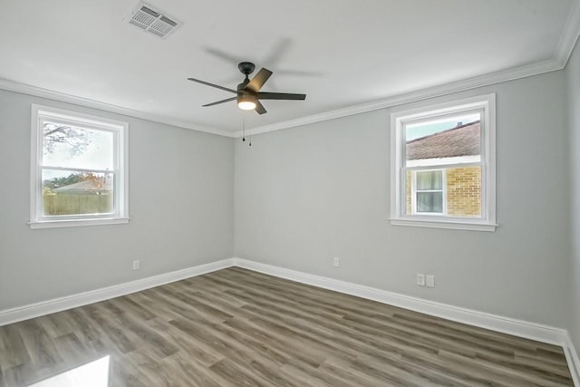 empty room with dark hardwood / wood-style flooring, plenty of natural light, crown molding, and ceiling fan