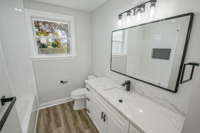 full bathroom featuring hardwood / wood-style floors, vanity, toilet, and shower / washtub combination