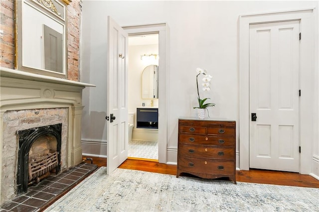 interior space featuring a tile fireplace, vanity, and wood-type flooring