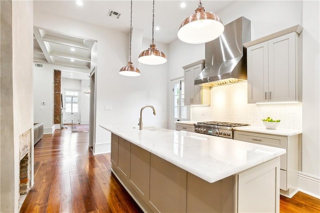 kitchen with pendant lighting, a spacious island, and wall chimney exhaust hood