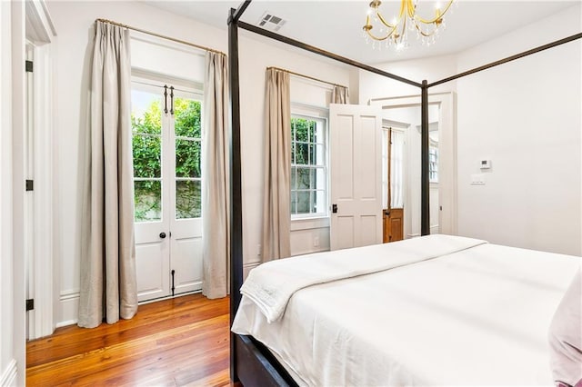 bedroom featuring hardwood / wood-style flooring and a notable chandelier