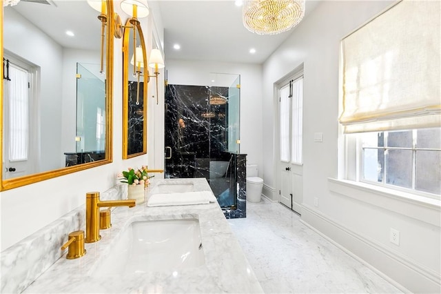 bathroom with a chandelier, vanity, toilet, and a shower with shower door