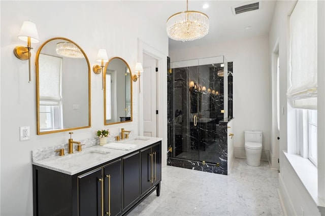 bathroom featuring vanity, toilet, a shower with door, and a notable chandelier