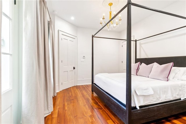 bedroom featuring a chandelier and wood-type flooring