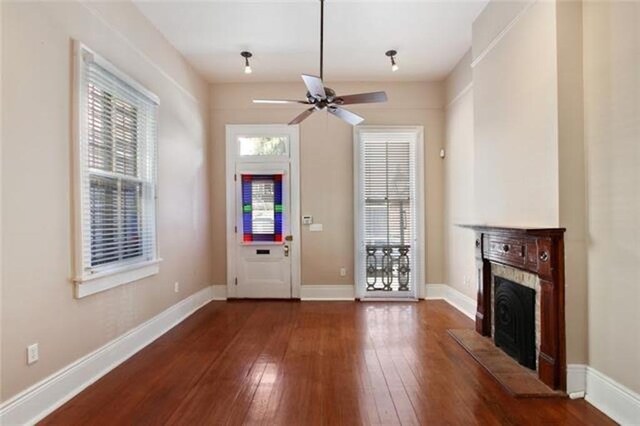 foyer featuring ceiling fan, dark hardwood / wood-style floors, and a fireplace