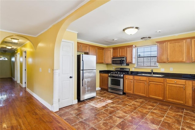 kitchen featuring sink, ornamental molding, and appliances with stainless steel finishes