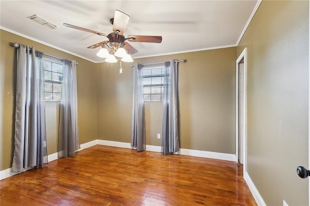 spare room featuring wood-type flooring, ceiling fan, and crown molding