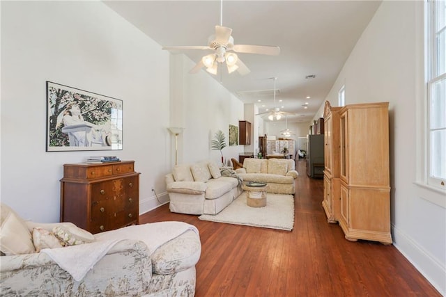 living room featuring ceiling fan and dark hardwood / wood-style floors