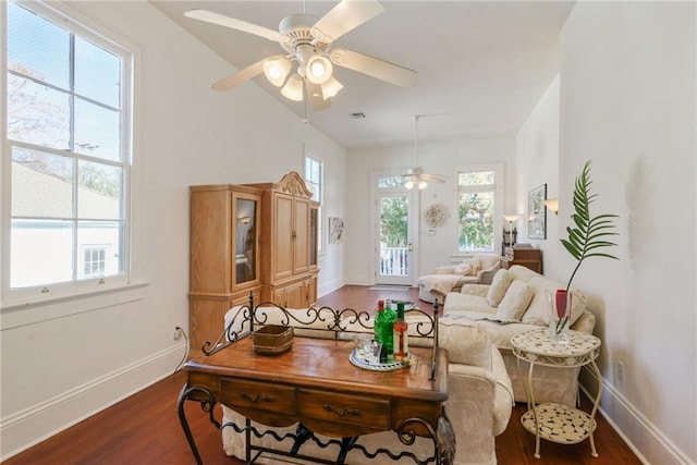 living room with a healthy amount of sunlight, ceiling fan, and dark wood-type flooring