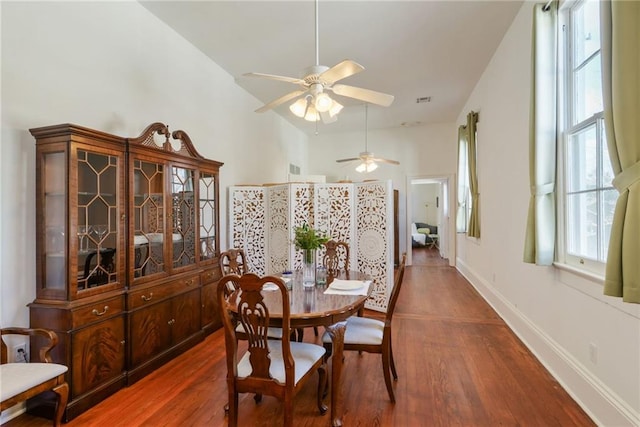 dining space with ceiling fan and dark wood-type flooring