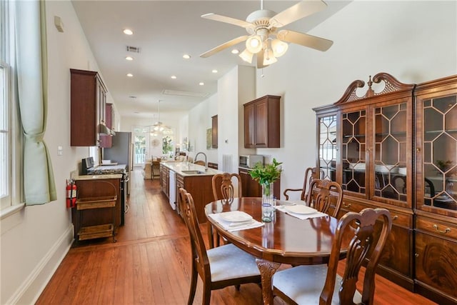 dining space with ceiling fan, sink, and hardwood / wood-style floors