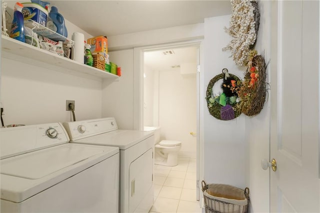 laundry room with independent washer and dryer and light tile patterned flooring