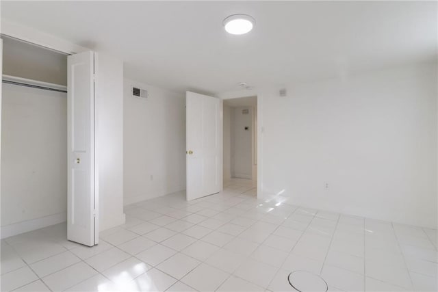 unfurnished bedroom featuring a closet and light tile patterned floors