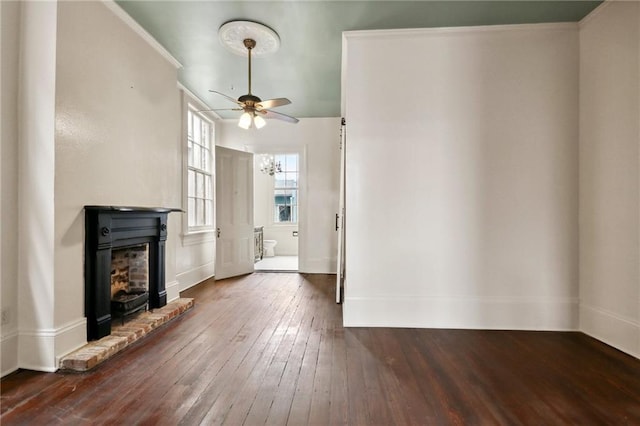 unfurnished living room with dark hardwood / wood-style flooring, a brick fireplace, and ceiling fan