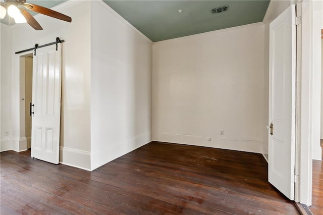 interior space featuring crown molding, dark hardwood / wood-style floors, a barn door, and ceiling fan