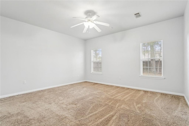 carpeted empty room with a wealth of natural light and ceiling fan