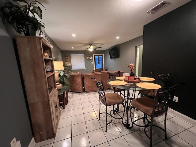 tiled dining space featuring ceiling fan